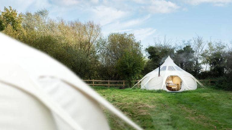 Luxury tipi tents in a field.