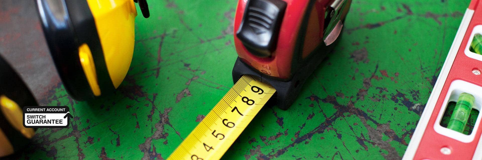 Ear protectors, a tape measure and a spirit level arranged on a workbench
