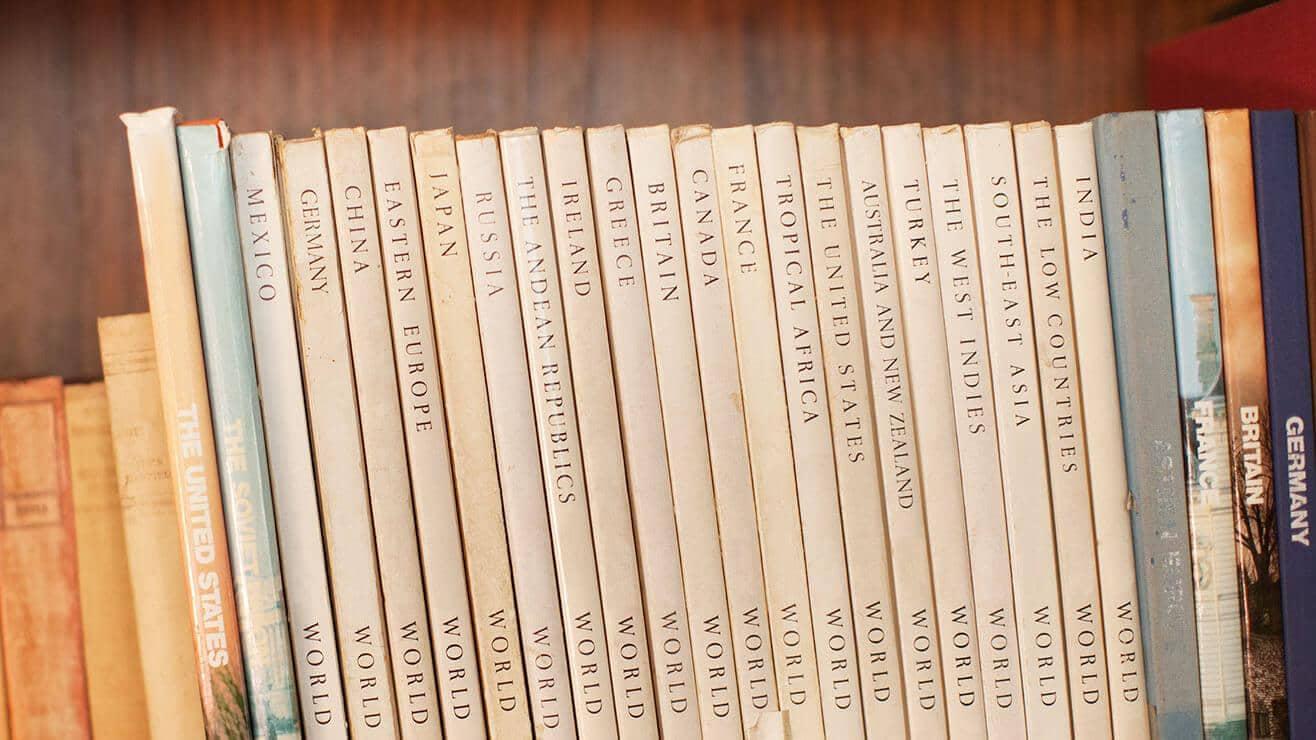 A line of books in a bookcase. The spines are names of different countries