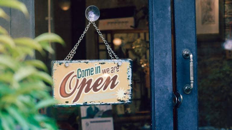 A shop sign on the door that says 'come in we are open'.