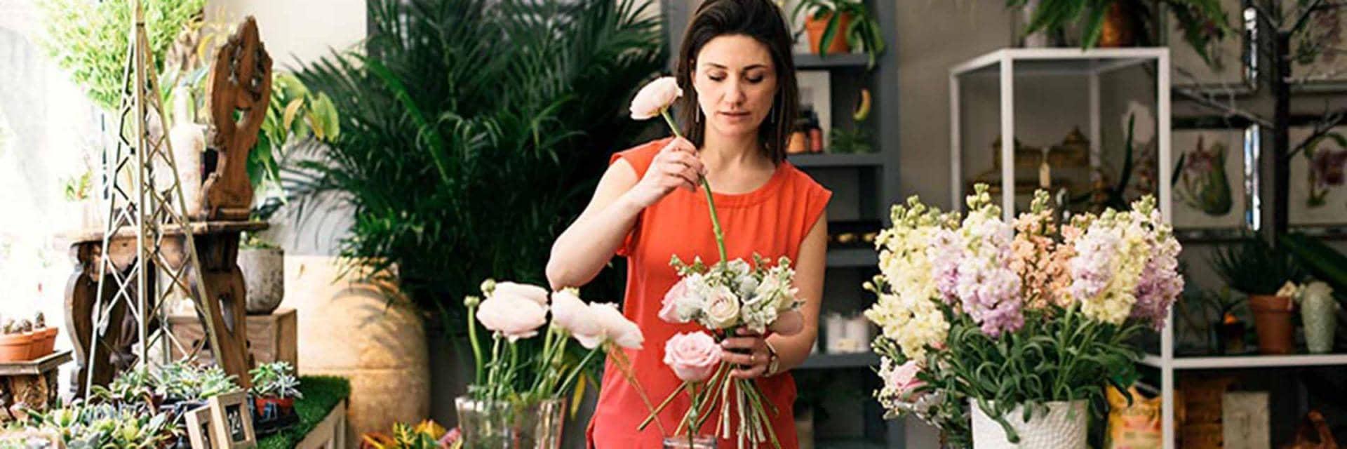 A woman is arranging flowers.
