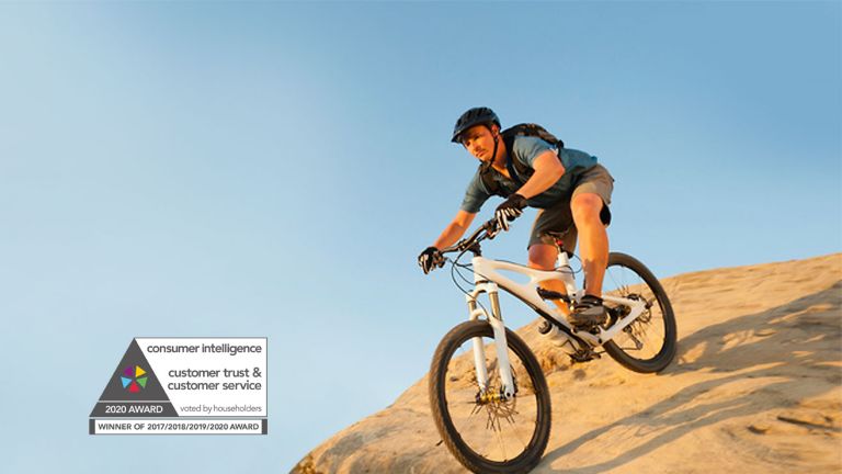 A man on a mountain bike riding down a sand dune
