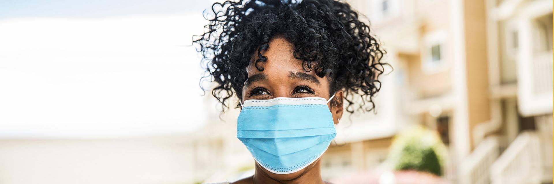 Woman smiling wearing surgical facemask 