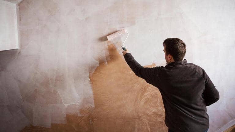  person painting wall with roller