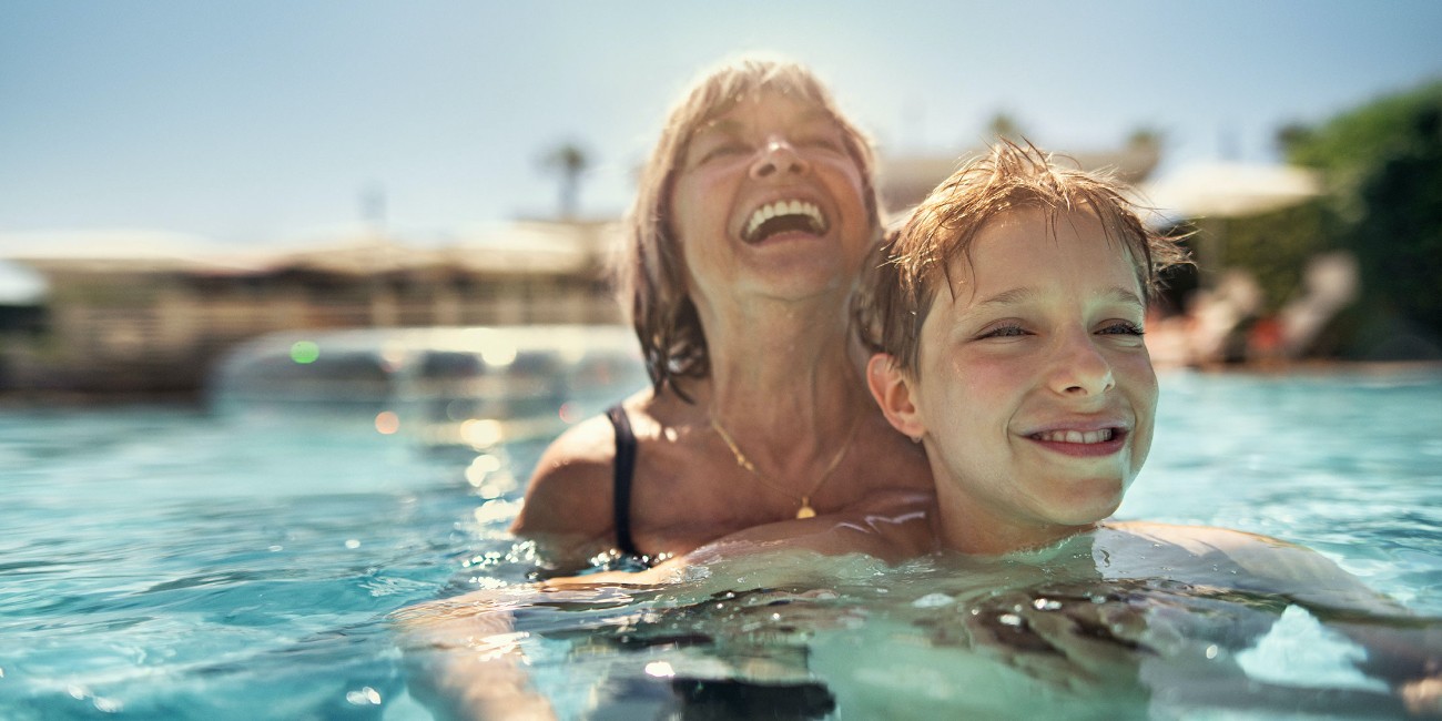 Mother and son in swimming pool laughing and having fun